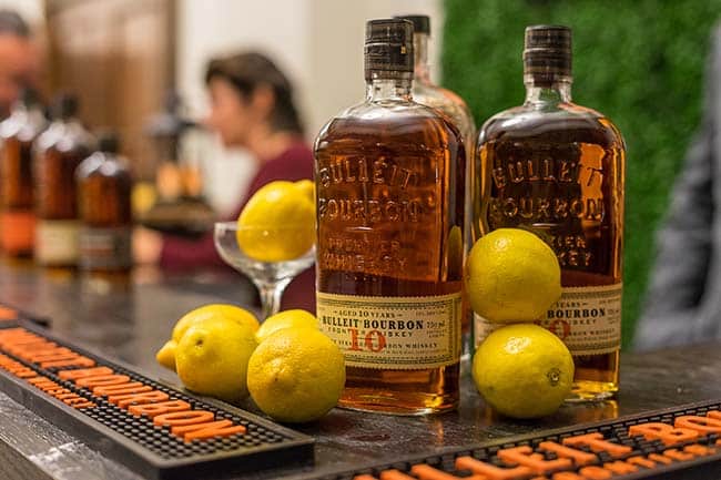 Bulleit Bourbon bottles displayed with fresh lemons on a bar setup—featured at a Louisville event with custom cocktail service by Michaelis Events.