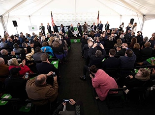 Corporate tented press event with full seated audience and stage presentation, coordinated by Michaelis Events – Top Event Planners in Louisville KY & Best Wedding Caterers.