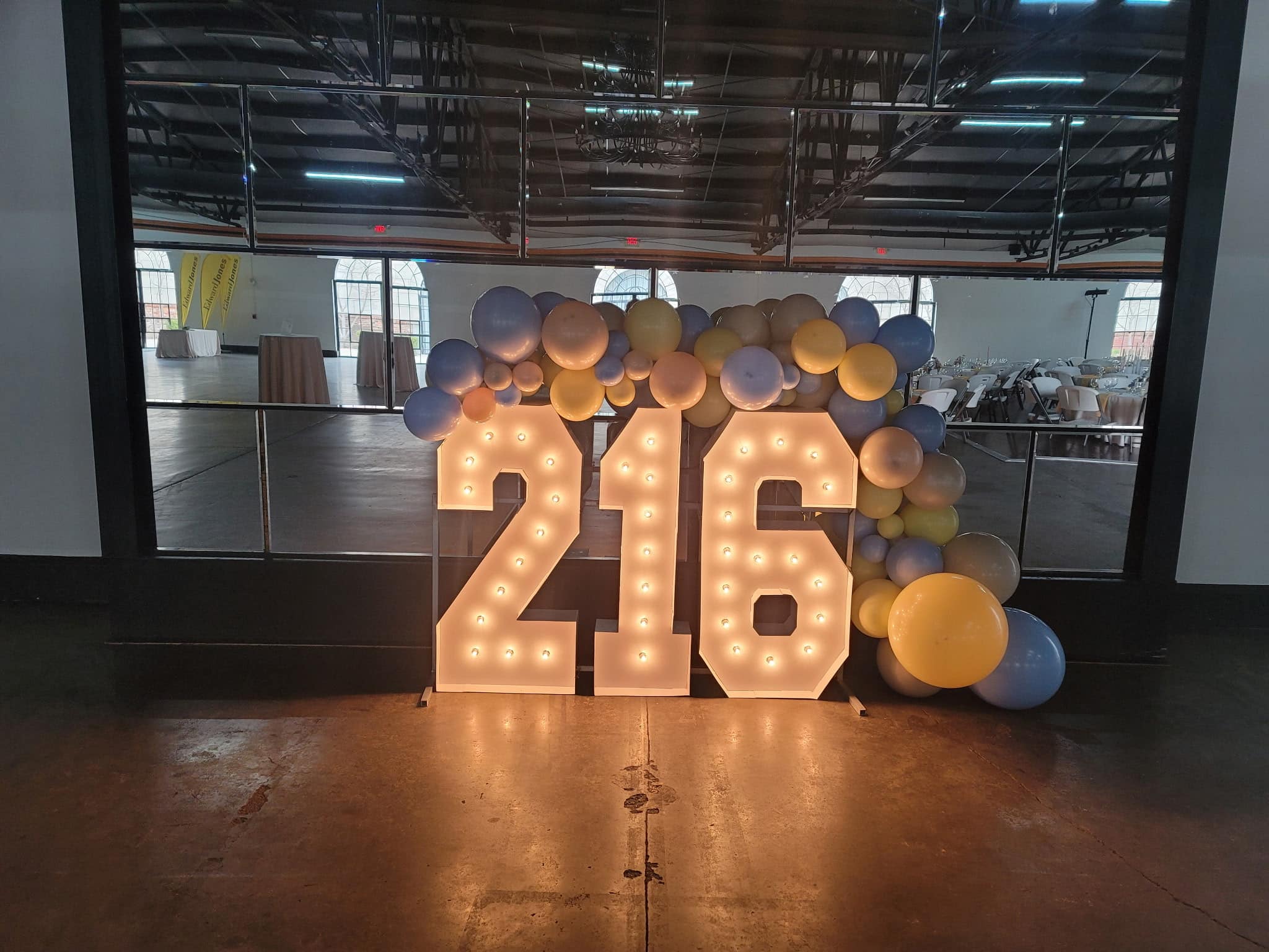 Illuminated marquee numbers "216" with pastel balloon garland at Louisville event venue