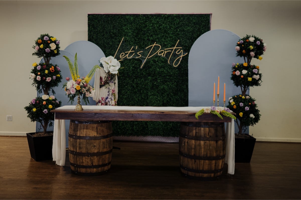 Rustic Derby-themed bar setup with floral accents and "Let's Party" sign at a Michaelis Events corporate celebration at the Frazier History Museum.