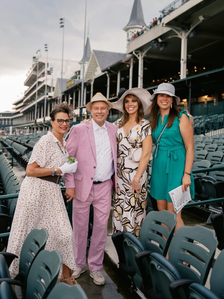 Derby-themed corporate event at Churchill Downs, expertly planned by Michaelis Events, featuring elegant red and black dรฉcor, signature mint juleps, and guests in classic Derby attire against the iconic racetrack backdrop.