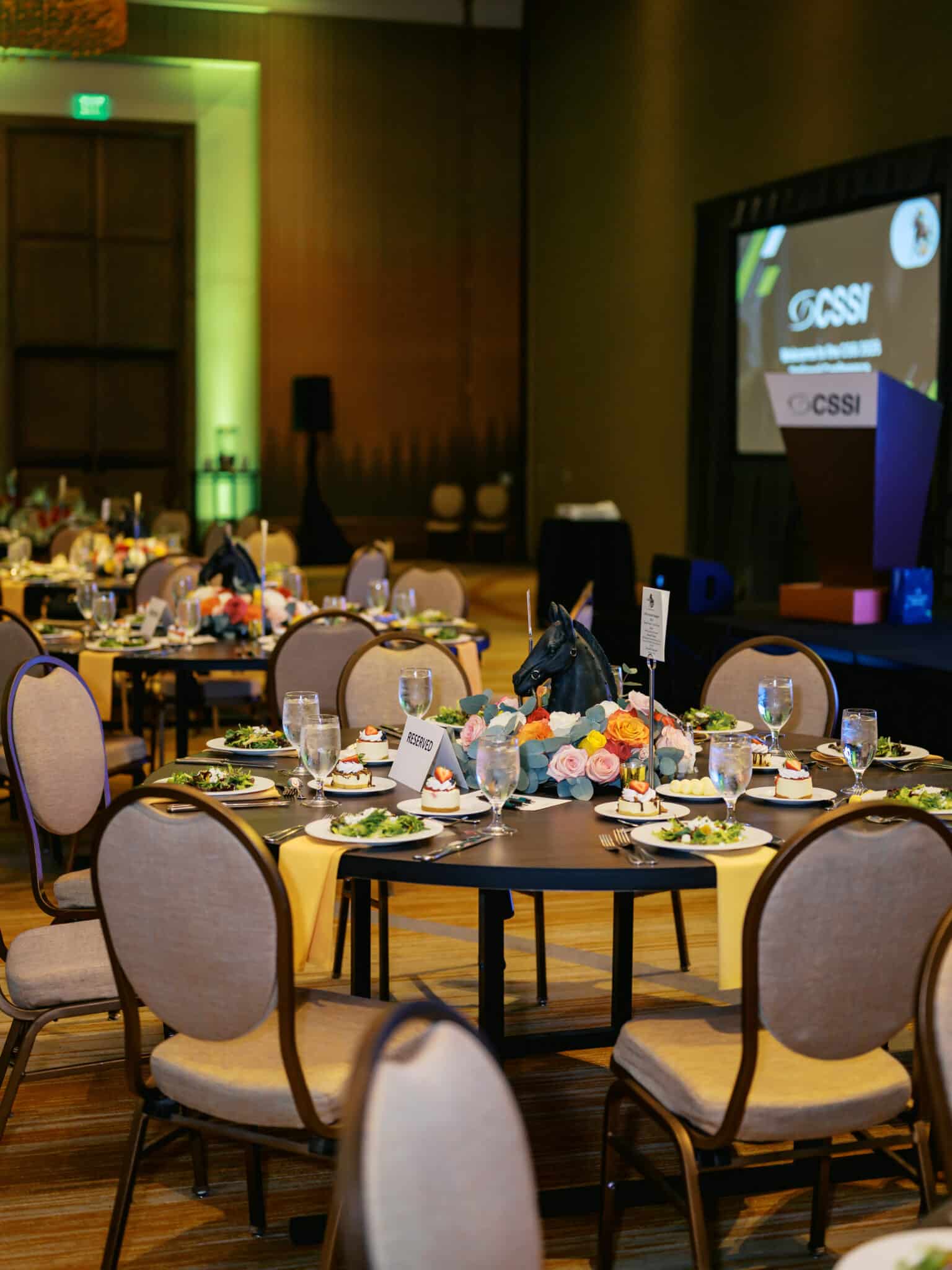 Guest tables dressed in black linens, red napkins, silver flatware, and overflowing rose centerpieces, part of the signature Derby décor by Michaelis Events at Omni Louisville.